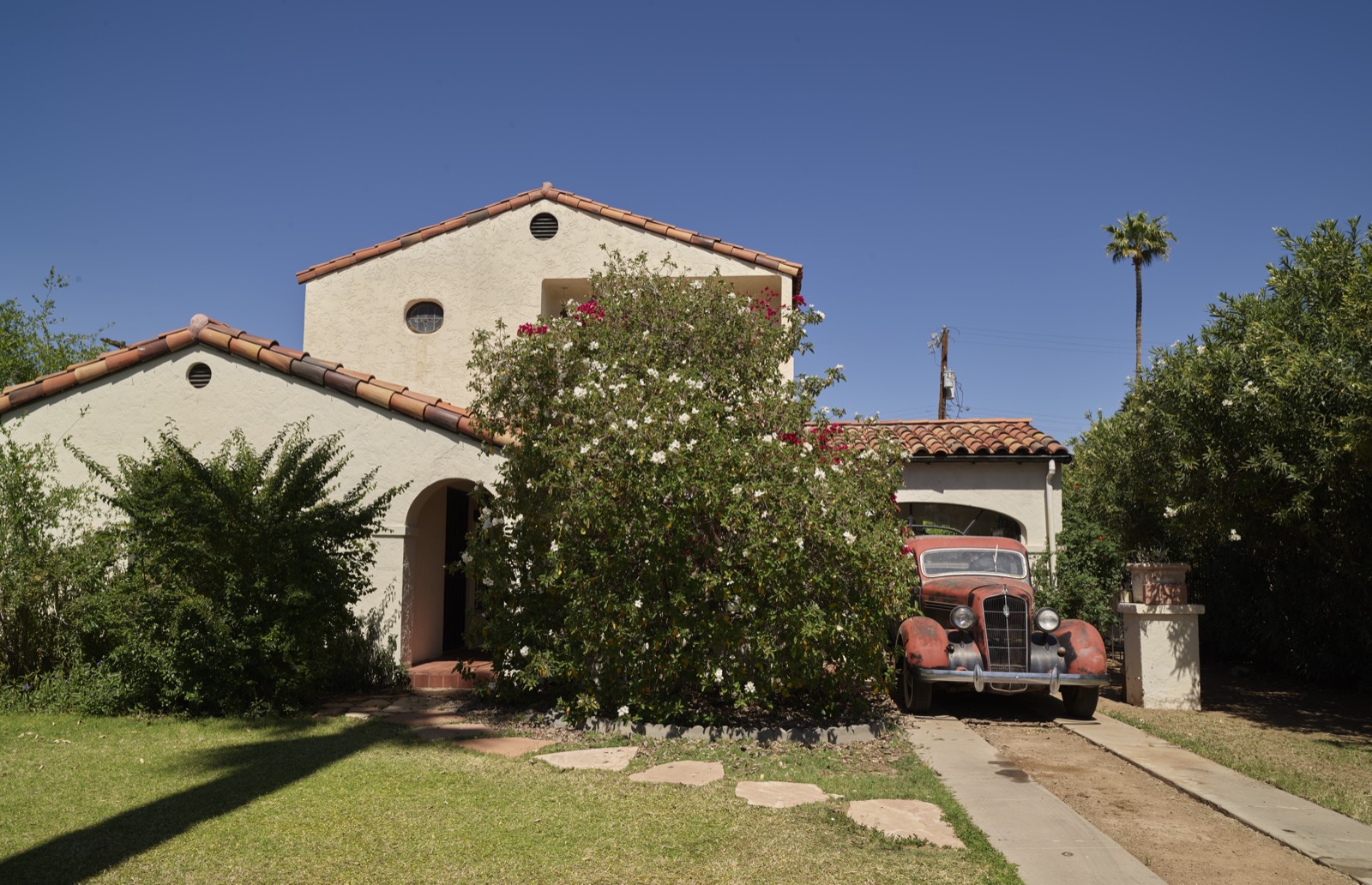 A two-storey Spanish Revival house with a tile roof and a 1930s car in the carport, Willo historic district, Phoenix